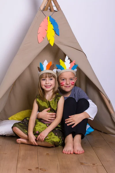Girl and boy in carnival costumes indians studio — Stock Photo, Image
