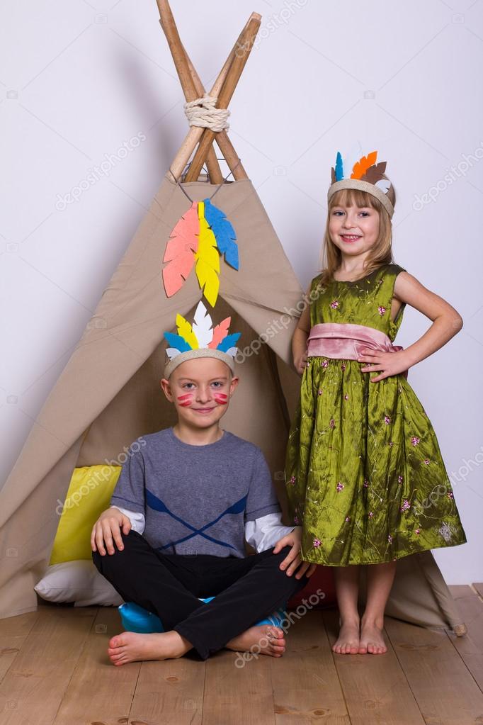 Girl and boy in carnival costumes indians studio