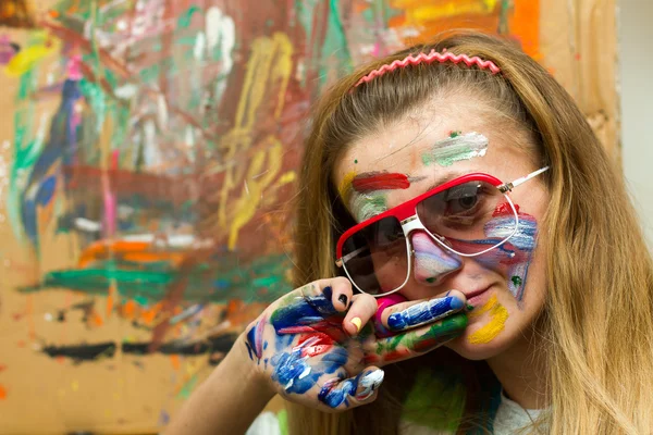 Девушка рисует улыбку красками — стоковое фото