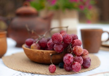Bulanık arkaplanı olan bir masada kilden yapılmış kırmızı üzümler.
