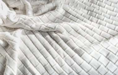 Yatağın üzerinde beyaz örülü battaniye, yukarıdan manzara 