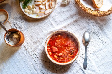 Ukrayna Borsch 'u. Krema, sarımsak, salo, beyaz kırsal masa örtüsü, yukarıdan manzara.