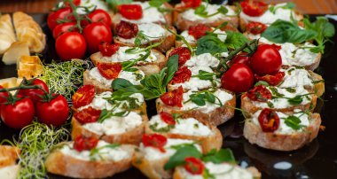 Peynirli, kirazlı, domatesli ve yeşillikli lezzetli sandviçlerin yakın çekimi.