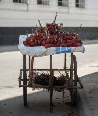 Satmak için olgun kırmızı rambutan ile sokak masası 