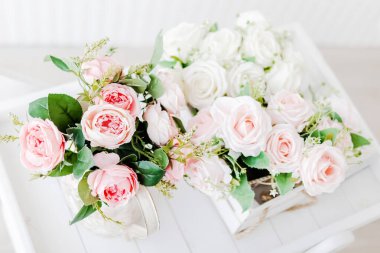 Yapay şakayık demeti ve güller açık ahşap arka planda.