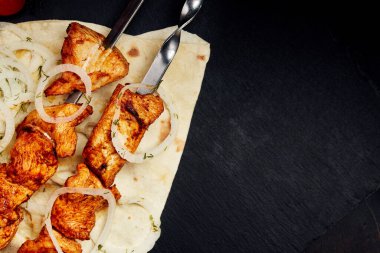 Şiş kebap, şiş kebap, koyu arkaplanda pide ekmeği.