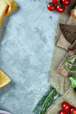 Çuval ekmeği, domates, yeşillik ve patlıcanla açık gri beton arka plan