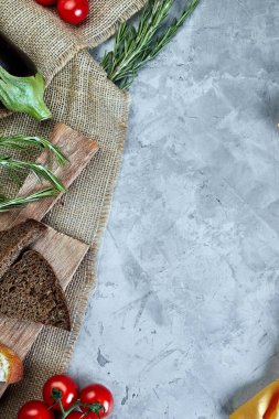 Çuval ekmeği, domates, yeşillik ve patlıcanla açık gri beton arka plan