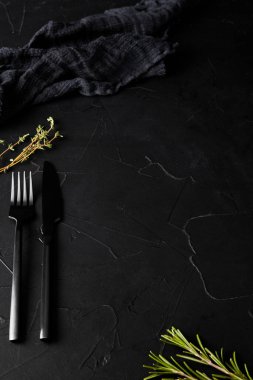 Siyah çatal, bıçak ve peçeteyle siyah desenli arka plan