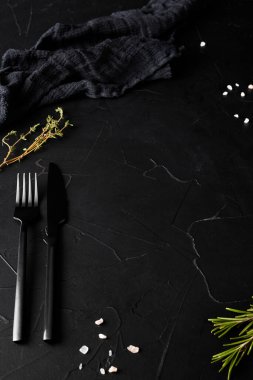 Siyah çatal, bıçak ve peçeteyle siyah desenli arka plan