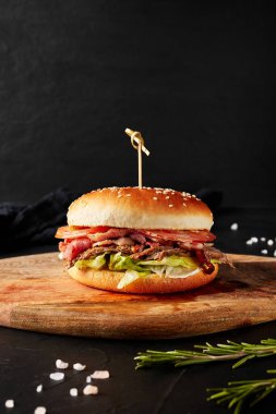 Tahtadaki hamburgerler siyah arka planda