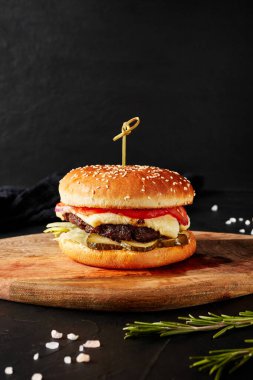 Tahtadaki hamburgerler siyah arka planda