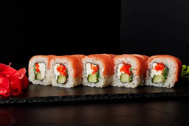 Kara desenli arkaplanda siyah bir tahta üzerinde yuvarlanıyor