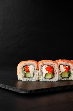 Kara desenli arkaplanda siyah bir tahta üzerinde yuvarlanıyor