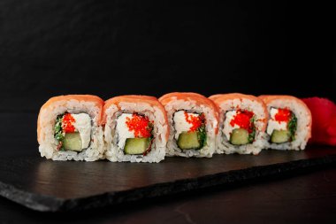 Kara desenli arkaplanda siyah bir tahta üzerinde yuvarlanıyor