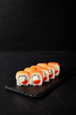 Kara desenli arkaplanda siyah bir tahta üzerinde yuvarlanıyor