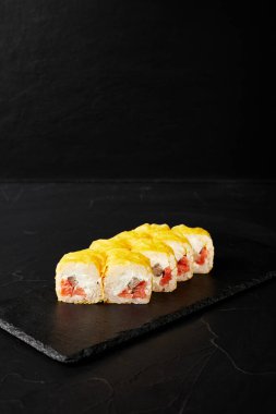 Kara desenli arkaplanda siyah bir tahta üzerinde yuvarlanıyor