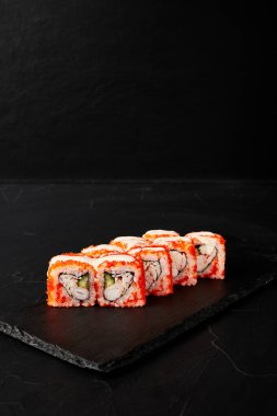 Kara desenli arkaplanda siyah bir tahta üzerinde yuvarlanıyor