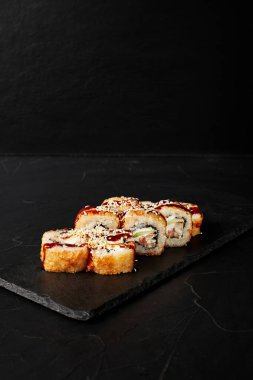 Kara desenli arkaplanda siyah bir tahta üzerinde yuvarlanıyor