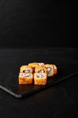 Kara desenli arkaplanda siyah bir tahta üzerinde yuvarlanıyor