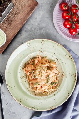 Gri beton desenli arka plan görünümlü tabak içinde makarna