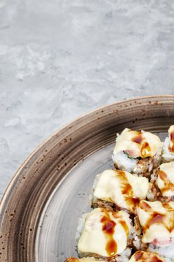 Gri beton desenli arka planda kahverengi plaka üzerinde yuvarlanıyor