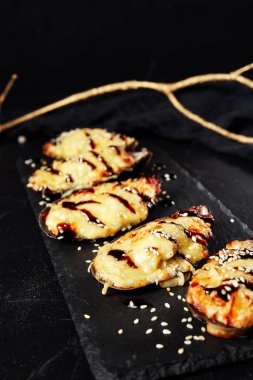 Kara tahtada pişmiş istiridye ve altın bir filiz.