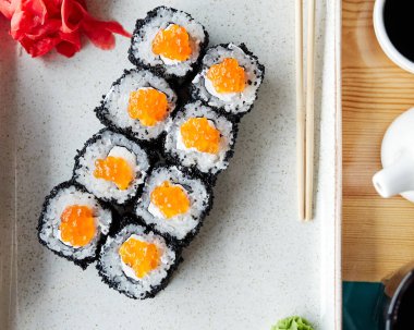 Tahta bir tahtanın üstünde çubuklarla beyaz bir tabakta yuvarlanıyor.