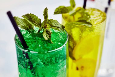 Hafif arka planda cam bardakta pipetli limonata.