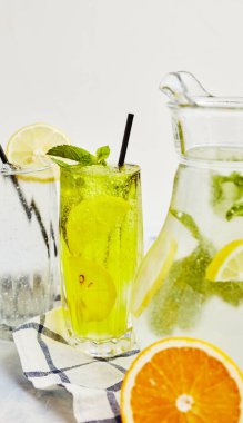 Hafif arka planda cam bardakta pipetli limonata.