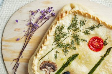 Tahtada süslemeli turta. Arka planda, kurumuş çiçeklerle birlikte.