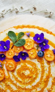 Portakal aromalı pasta. Portakal dilimleri ve çiçeklerle süslenmiş.