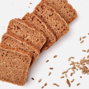 Beyaz bir tabakta dilimlenmiş çavdar ekmeği ve kabak çekirdeği. 