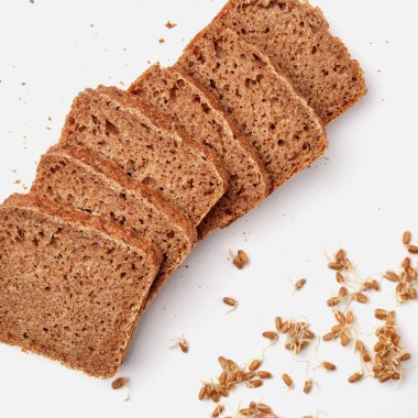 Beyaz bir tabakta dilimlenmiş çavdar ekmeği ve kabak çekirdeği. 