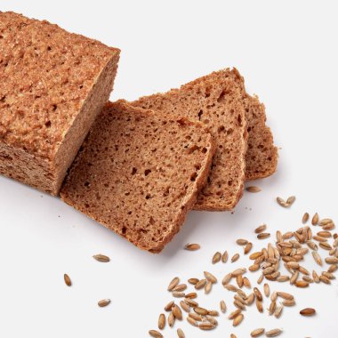 Beyaz bir tabakta dilimlenmiş çavdar ekmeği ve kabak çekirdeği. 