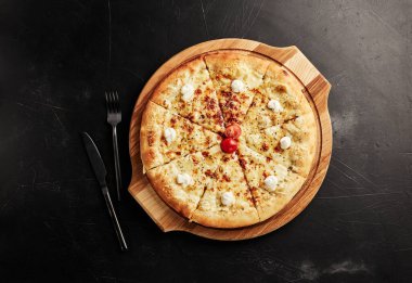Siyah desenli arka plan görünümlü ahşap tabanlı pizza.