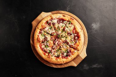 Siyah desenli arka plan görünümlü ahşap tabanlı pizza.