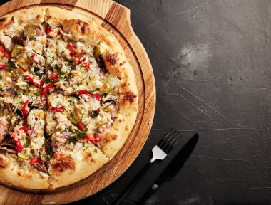 Siyah desenli arka plan görünümlü ahşap tabanlı pizza.