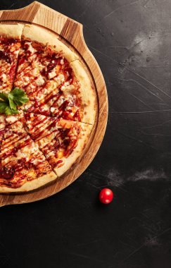 Siyah desenli arka plan görünümlü ahşap tabanlı pizza.