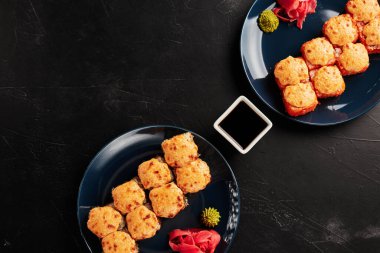 Siyah desenli arka planda, tabaklarda fırınlanmış rulo