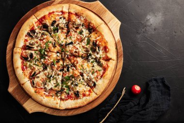 Siyah desenli arka plan görünümlü ahşap tabanlı pizza.