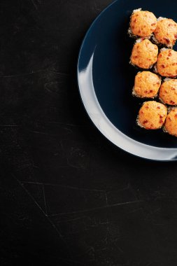 Siyah desenli arka planda, tabaklarda fırınlanmış rulo