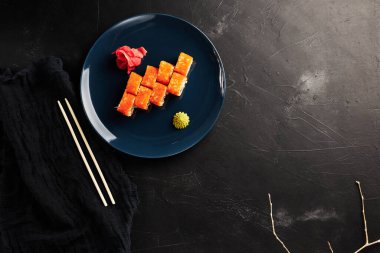 Siyah desenli arka planda mavi bir tabakta havyarda yuvarlanıyor.