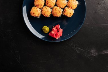 Siyah desenli arka planda, tabaklarda fırınlanmış rulo