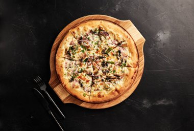 Siyah desenli arka plan görünümlü ahşap tabanlı pizza.