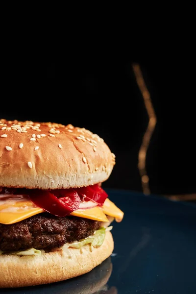 Burger Modrém Talíři Černém Pozadí Zlatou Větvičkou Nad Hlavou Boční — Stock fotografie