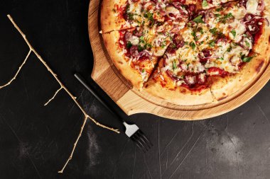 Siyah desenli arka plan görünümlü ahşap tabanlı pizza.