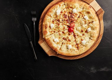 Siyah desenli arka plan görünümlü ahşap tabanlı pizza.
