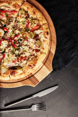 Siyah desenli arka plan görünümlü ahşap tabanlı pizza.