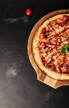 Siyah desenli arka plan görünümlü ahşap tabanlı pizza.